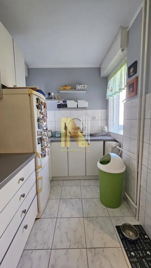 Manja kuhinja sa belim elementima i frižiderom.