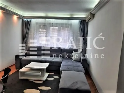 Living room with a corner sofa, coffee table, and rug.