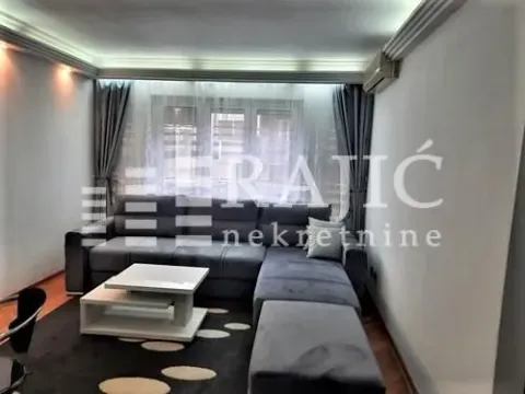 Living room with a corner sofa, coffee table, and rug. - image 2