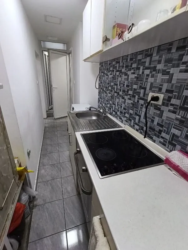Manja uža kuhinja sa ugradnom pločom i sudoperom.