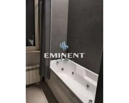 Bathroom with a whirlpool bathtub and dark wall tiles. - image 5