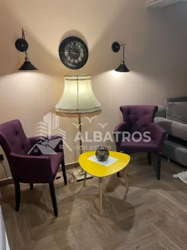 Living room with two purple armchairs, a coffee table, and a lamp. - image 6