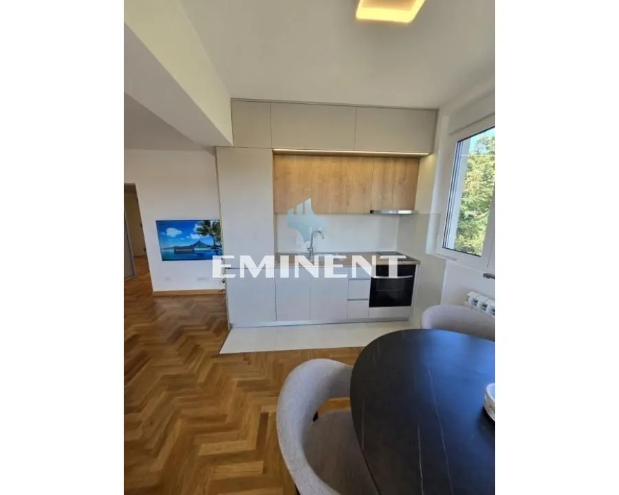 Modern kitchen with built-in appliances and a dining table.