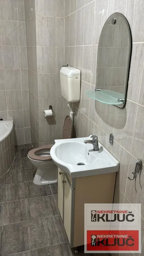 Manje kupatilo sa umivaonikom, ogledalom i wc šoljom.