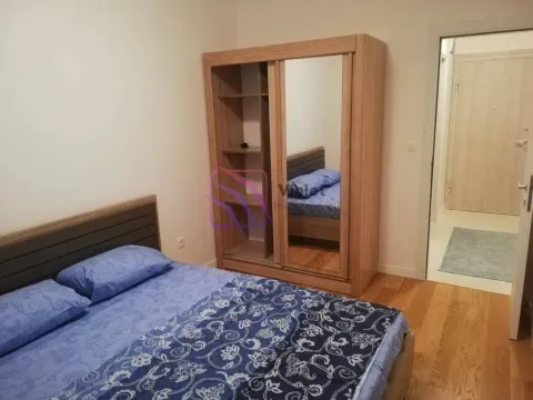 Furnished bedroom with a double bed and a wooden wardrobe with a mirror. - image 5