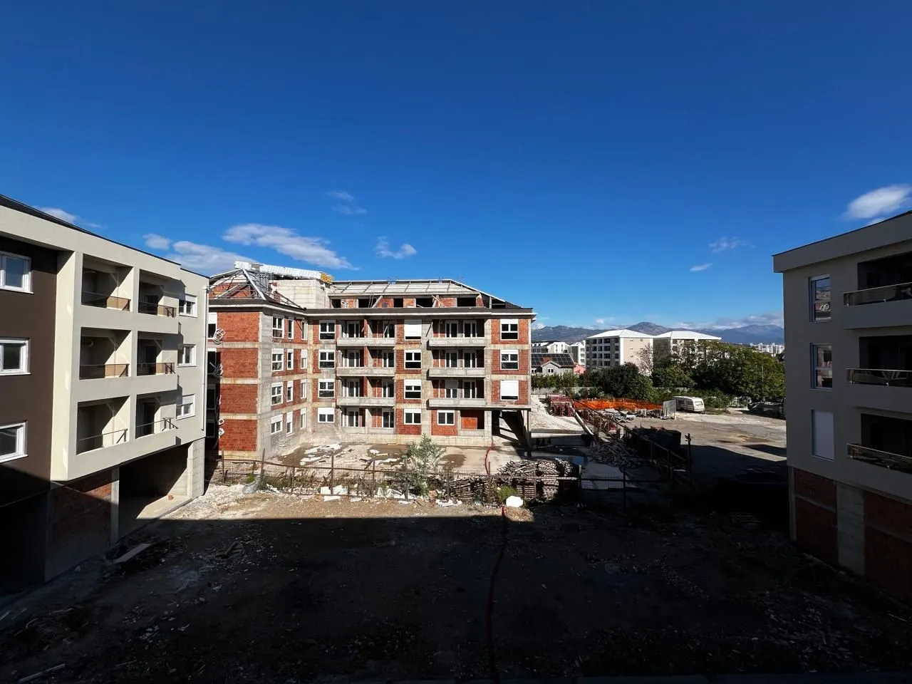 Pogled na stambenu zgradu u izgradnji sa okolnim dvorištem.