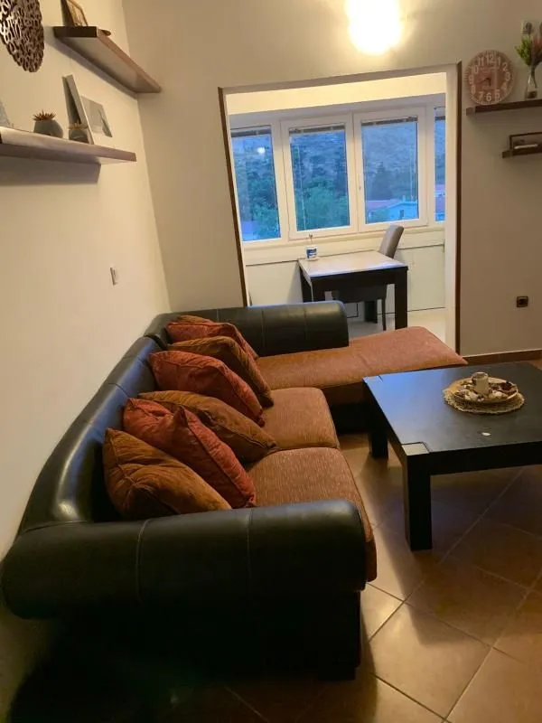 Living room with a sofa and coffee table, overlooking the enclosed terrace.
