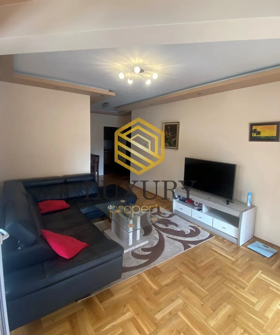 Spacious living room with a sofa and television.