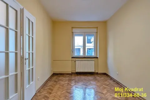 Prazna soba sa parketom, belim dvokrilnim vratima i prozorom. - image 7