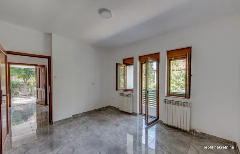 Prazna prostorija sa svetlim zidovima, sjajnim pločicama i prozorima koji gledaju na dvorište. - image 12