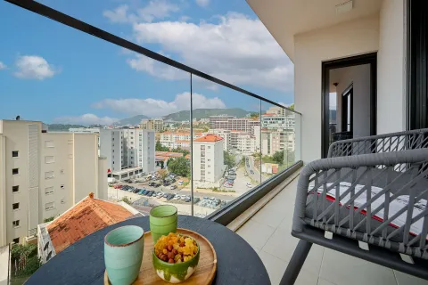 Namješten balkon sa stolom, stolicama i pogledom na grad. - image 9