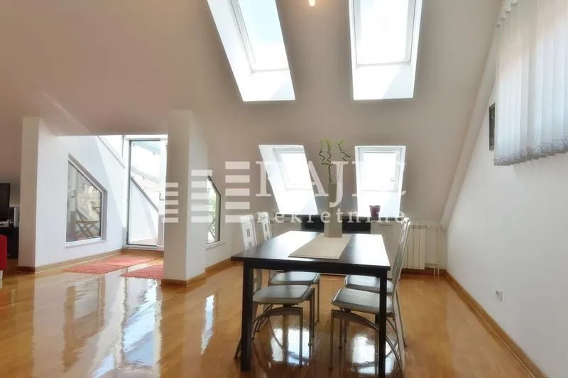 Spacious living room with a dining area and sloped ceiling.