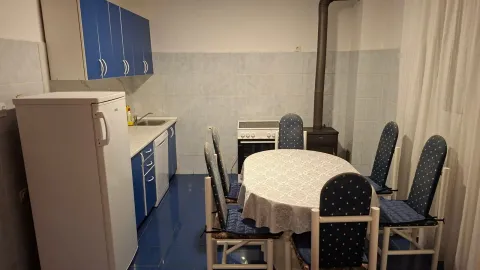 Kuhinja sa plavim elementima i trpezarijskim stolom sa stolicama. - image 12