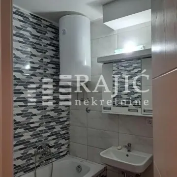 View of a furnished bathroom with a bathtub, washbasin, and water heater. - image 14