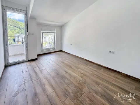 Prazna soba sa drvenim podom, bijelim zidovima i izlazom na balkon. - image 3