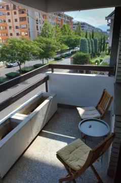 Furnished balcony with seating set and street view. - image 10