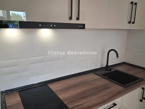 Modern kitchen with a built-in cooktop, sink, and wall cabinets. - image 2