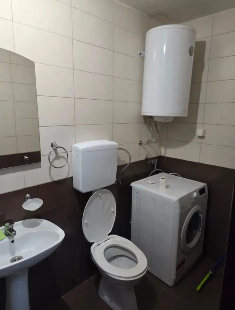 Kupatilo opremljeno umivaonikom, WC šoljom, veš mašinom i bojlerom.