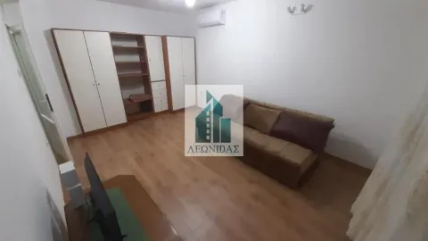 Living room with a sofa, television, and built-in wardrobe. - image 4
