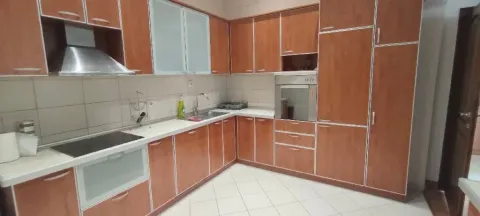 Corner kitchen with wooden cabinetry, built-in oven and cooktop. - image 12