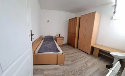 Manja spavaća soba sa krevetom, ormarima i laminatom na podu. - image 8