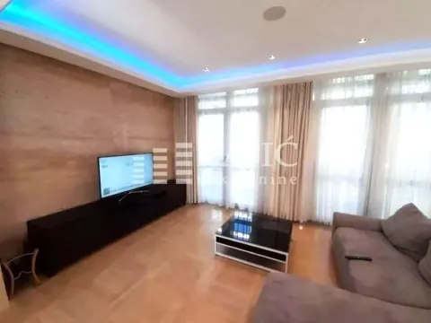 Living room with a sofa, TV, and drop ceiling with lighting. - image 17