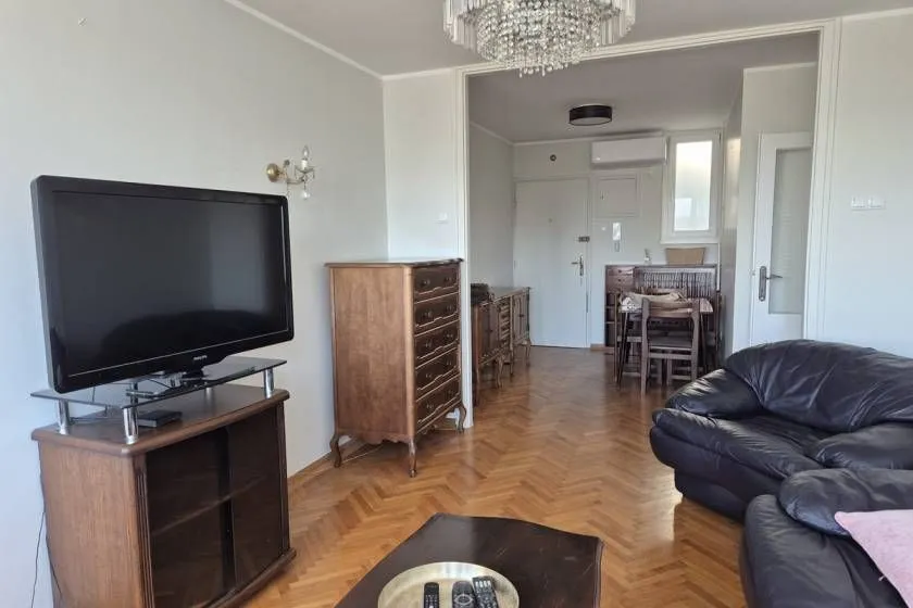 Living room with a sofa set, television, and wooden furniture.