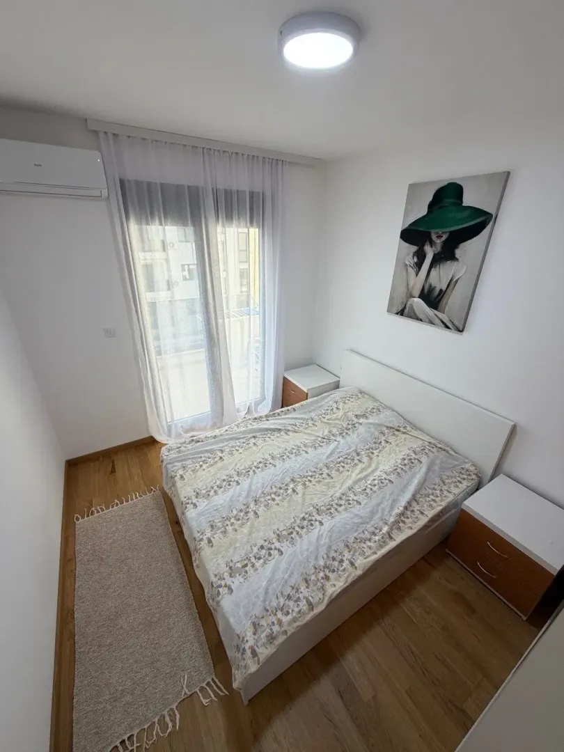 Bedroom with a double bed, nightstands, and balcony access.