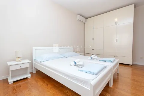 Svijetla spavaća soba sa bračnim krevetom, bijelim noćnim stočićem i garderoberom. - image 18