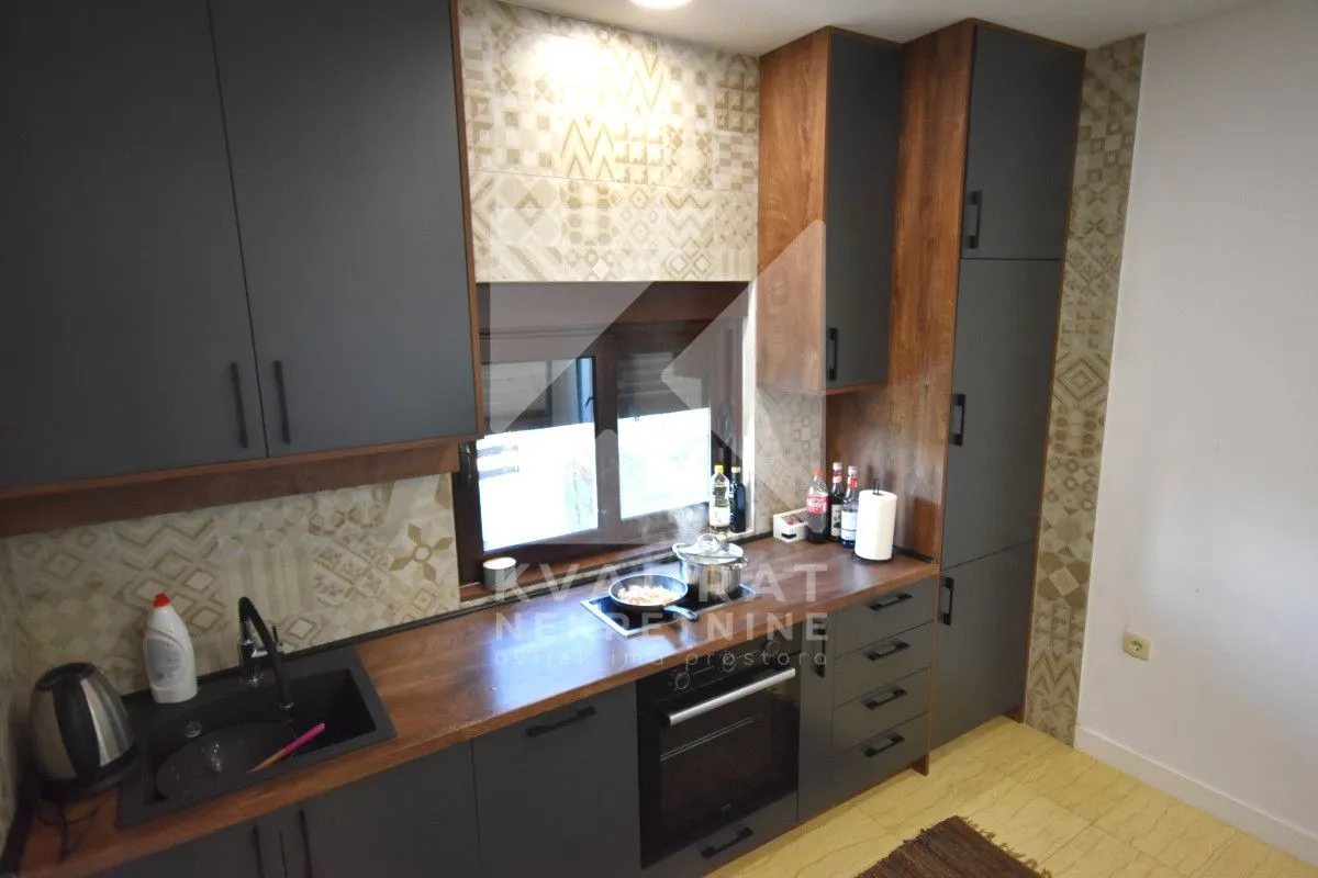 Modern kitchen with dark cabinets and a wooden countertop.