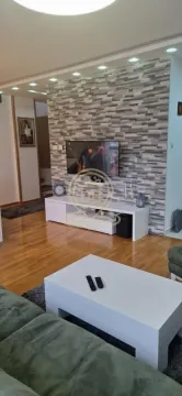 Dnevna soba sa garniturom, TV-om i belim komadom nameštaja. - image 11