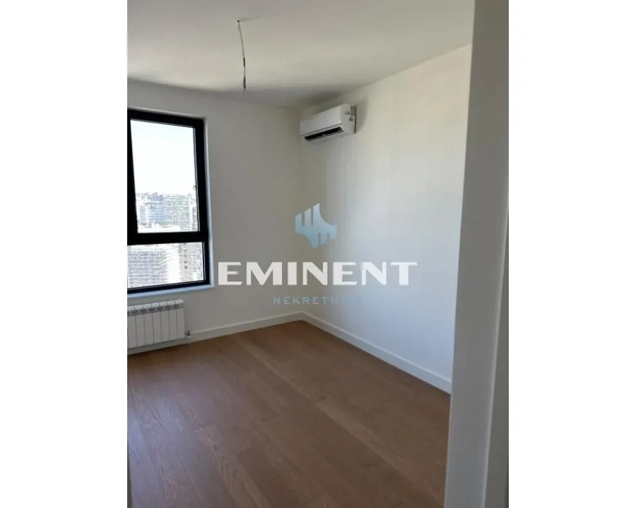 Empty room with parquet flooring, an air conditioning unit, and a window.