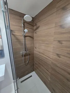 Moderne kupatilo sa tuš kabinom i zidnim pločicama u imitaciji drveta. - image 10