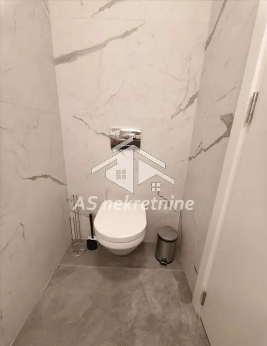 Manje kupatilo obloženo keramičkim pločicama sa ugradnom WC šoljom.