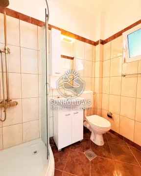 Compact bathroom with a shower cabin, washbasin, and toilet. - image 7