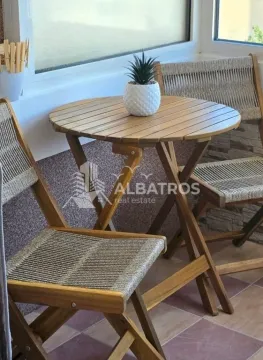 Small wooden table with chairs on a glazed balcony. - image 12