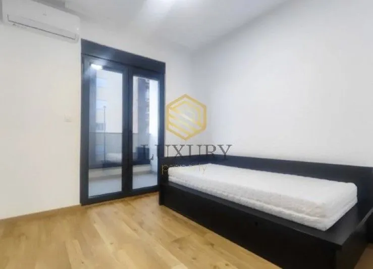 Smaller bedroom with a bed and access to the terrace.