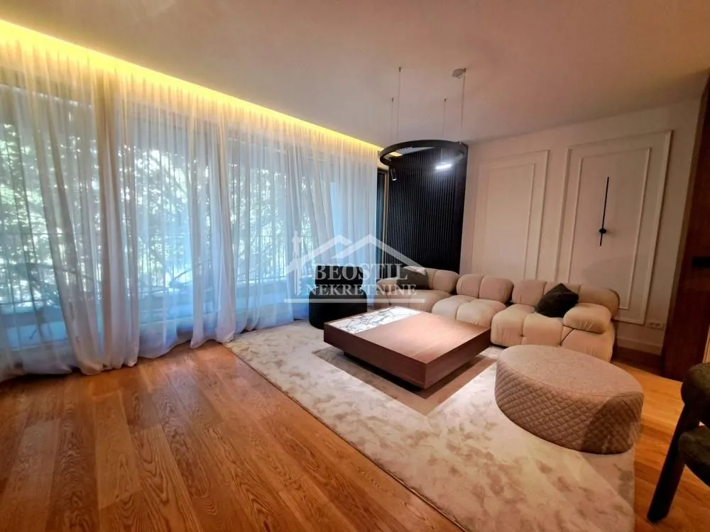 Modern living room with a sofa and large windows with curtains.
