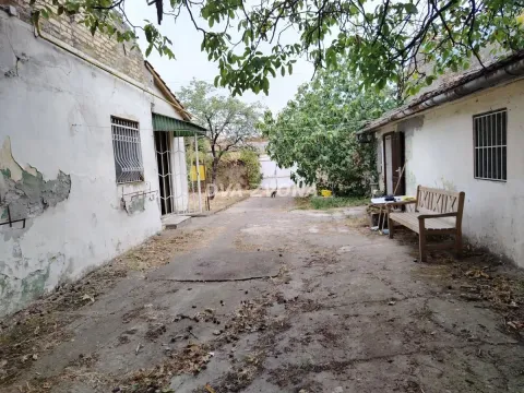 Pogled na dvorište i objekte sa drvenom klupom. - image 2