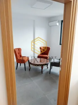 Living room with armchairs and a coffee table, viewed through a doorway. - image 3