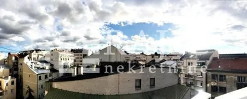 View from the terrace overlooking city roofs and buildings.
