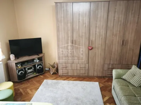 Dnevna soba sa velikim drvenim ormanom, televizorom i garniturom. - image 6