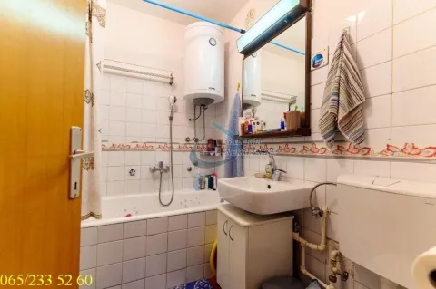 Smaller bathroom with a bathtub, washbasin, water heater, and toilet. - image 7