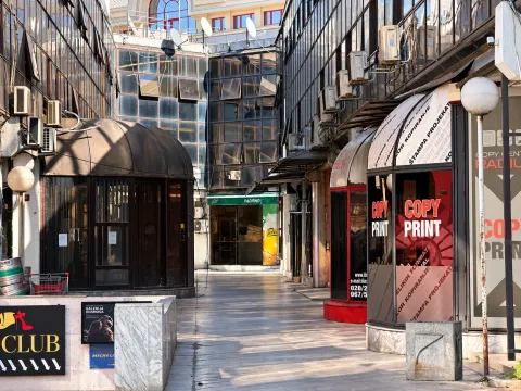 View of a passage between buildings with commercial premises and glass facades. - image 10