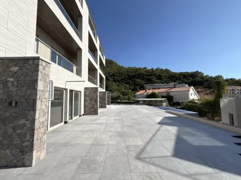 Pogled na prostranu terasu i spoljašnjost moderne stambene zgrade. - image 6