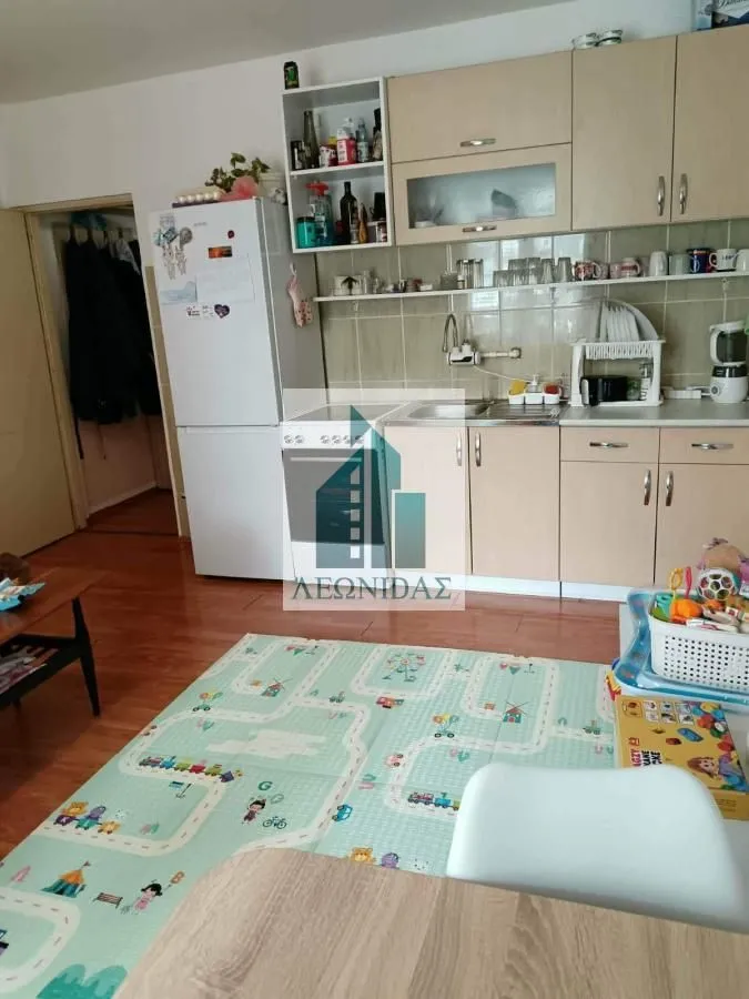 Kuhinja opremljena drvenim elementima sa frižiderom i šporetom.