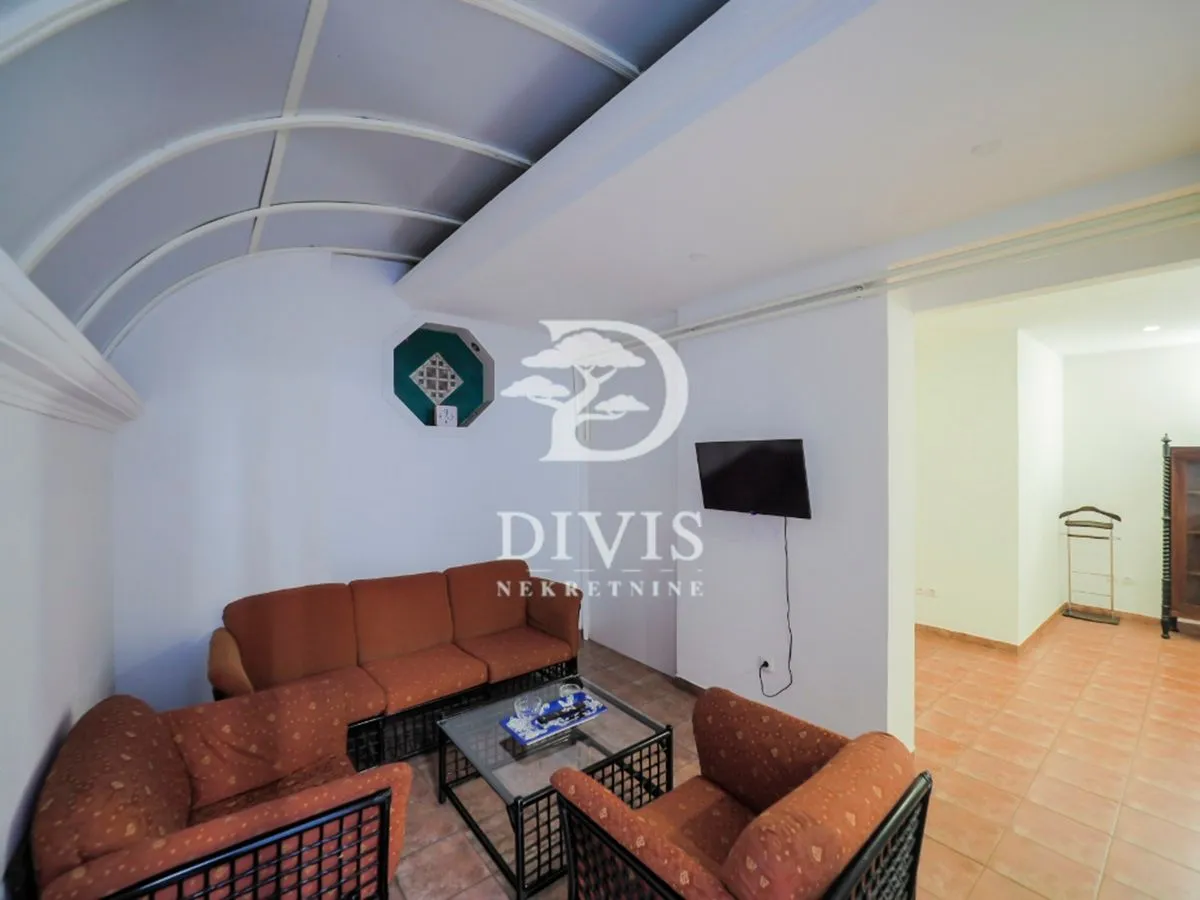 Living room with a seating set and a wall-mounted TV.