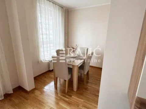 Dining area with a table and chairs by the window. - image 4