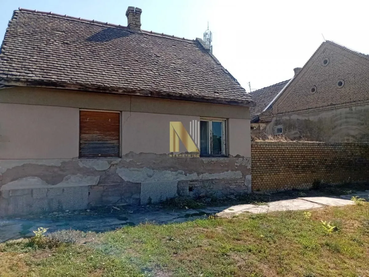 Eksterijer starije kuće sa dvorištem.