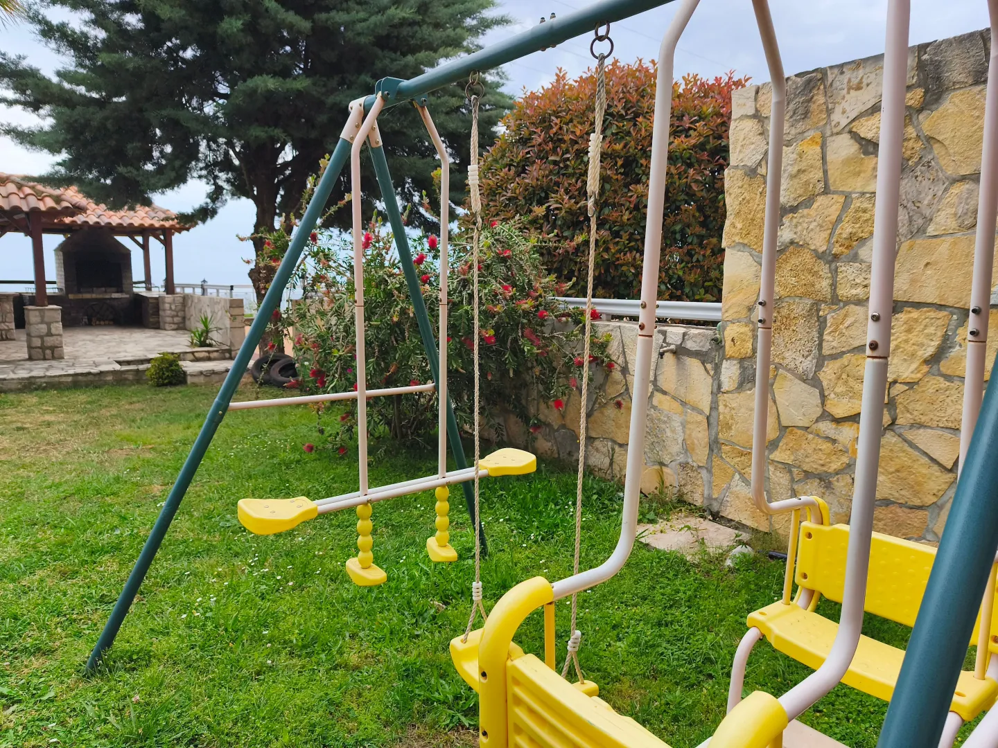 Dvorište sa dečijom ljuljaškom i pogledom na letnjikovac.